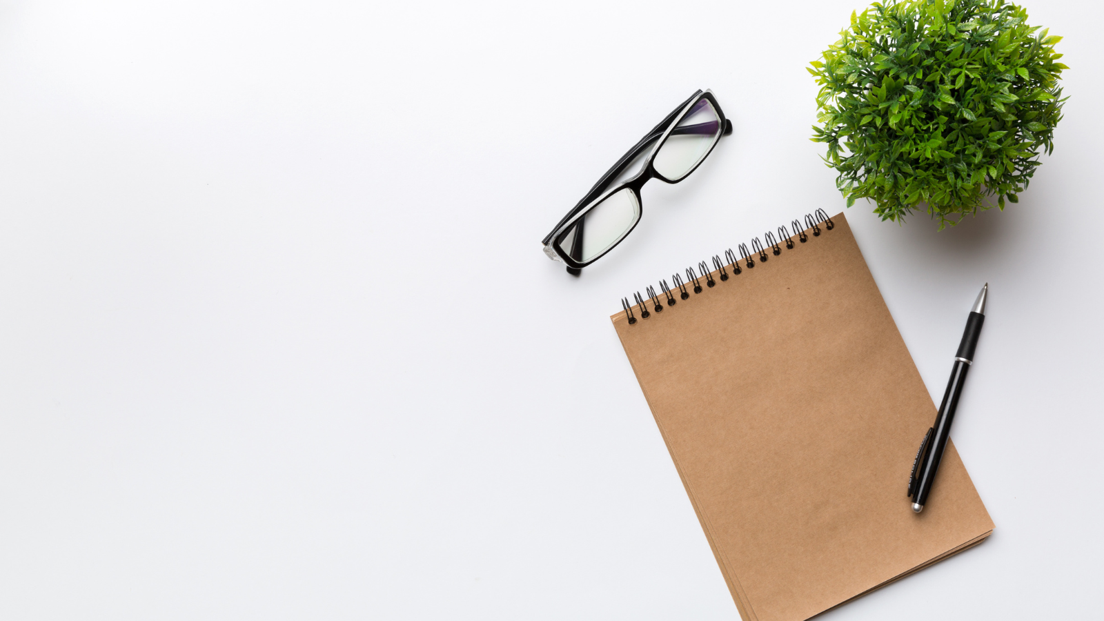 minimalist brown notebook with a pen and an eyeglasses